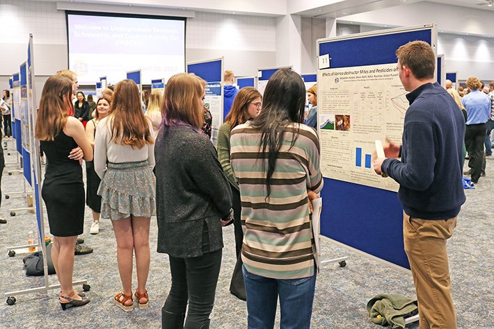 Visitors listen to poster presentations at SDSU's Undergraduate Research, Scholarship and Creative Activity Day on April 20 in the Volstorff Ballroom.