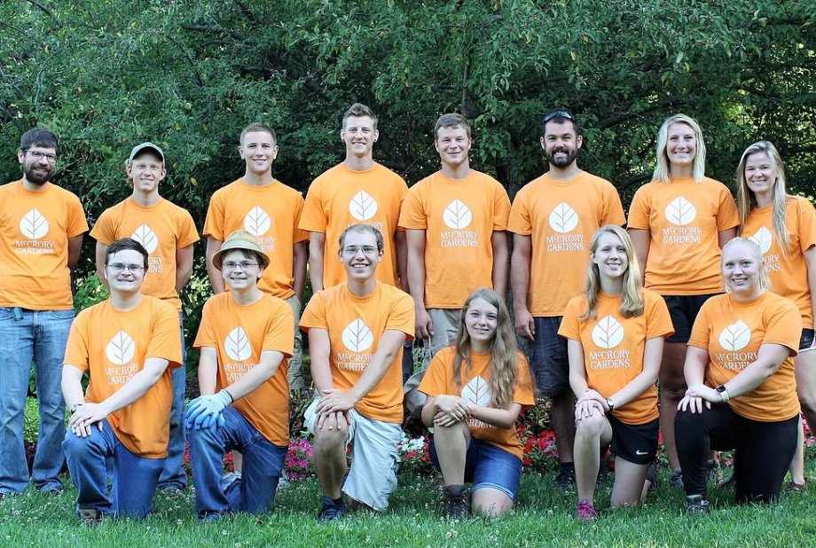 14 members of the McCrory Gardens summer team wearing matching orange t-shirts.