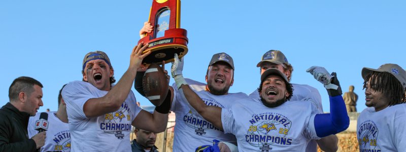 Players from the 2022 FCS Championship team yelling and holding the NCAA trophy in the air.