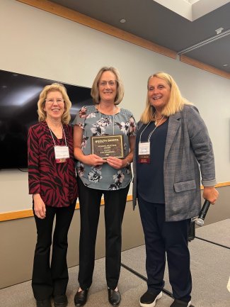 SDSU faculty member Lori Hendrickx, center, is honored as Nursing Practice Award winner at the gathering of the South Dakota Nurses Association in Huron Oct. 2. She is flanked by Kay Foland, left, a retired SDSU faculty member and 2022-23 vice president of the association, and association president Deb Fischer-Clemens.